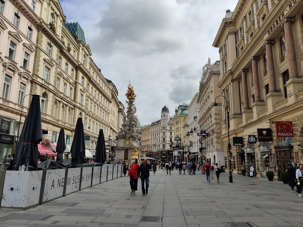 71 Fragmente einer Chronologie des Zufalls : Marian asks passers-by for change at the corner of Kupferschmiedgasse