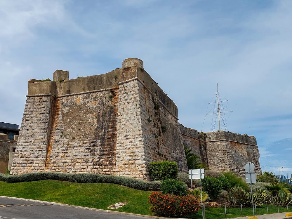 Der Ruf der blonden Göttin : Mrs. House arrives from the cruise ship Lobito and enters a car by the south wall of the fortress.